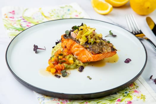 red fish with vegetable sauce and puree on a round plate