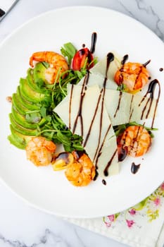 shrimp with avocado slices and arugula with teriyaki sauce