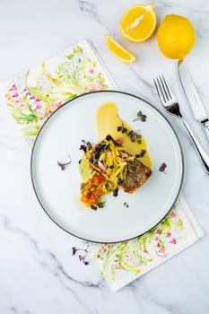 red fish with vegetable sauce and puree on a round plate