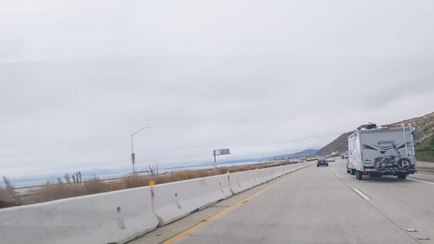 Los Angeles, California, USA-December 4, 2022-POV-Driving along Highway 101 near Rincon Beach, California, amidst a gloomy, cloudy winter day.