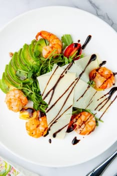 shrimp with avocado slices and arugula with teriyaki sauce