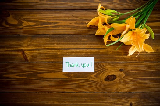 bouquet of beautiful yellow lilies on a dark wooden table