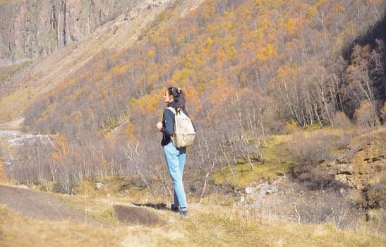 Travel. The girl travels through the mountains and waterfalls of the wild. Unity, mental health, eco-travel. Hiking, traveling, good times, digital detox.