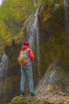 Travel. The girl travels through the mountains and waterfalls of the wild. Unity, mental health, eco-travel. Hiking, traveling, good times, digital detox