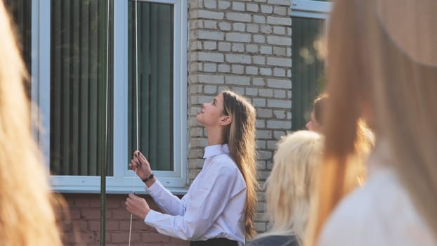 A student raises the flag of the country on the days of knowledge