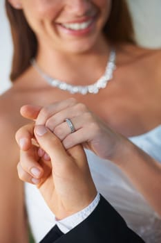Couple, wedding ring and hands together in marriage with bride and smile at celebration and trust event. Flower, loyalty and care with romance and jewelry with love and commitment with woman and man.