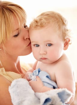 Love, kiss and face of baby with mother in a house for bonding, playing or care, trust or growth. Family, support and mom embrace boy kid in their home for child development, security or having fun.