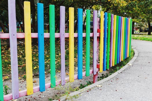 Photo a multicolored low wooden fence. Fencing flower beds, a barrier from children and animals.