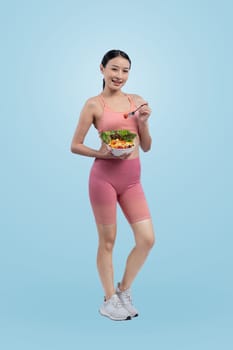 Young sporty Asian woman in sportswear holding salad bowl fill with vibrant of fruit and vegetable. Natural youthful and fit body lifestyle with balance nutrition on isolated background. Vigorous