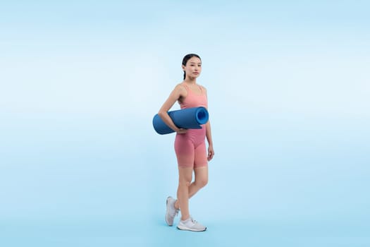 Young attractive asian woman portrait in sportswear with exercising mat. Healthy exercise and workout routine lifestyle concept. Studio shot isolated background. Vigorous