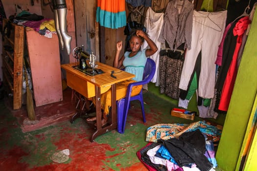 Malindi, Kenya - April 06, 2015: Unknown local woman, tailor, sitting by her sewing machine. New dresses are often made by locals from clothes donated by tourists