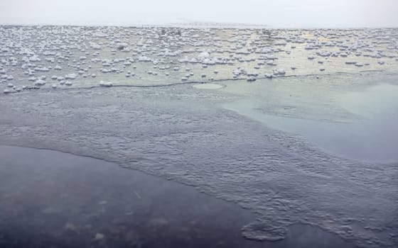 Ice on frozen lake / pond, small patches of snow on flat surface