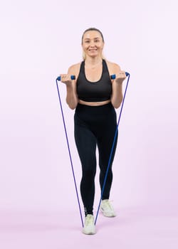 Full body length shot athletic and sporty senior woman with fitness exercising rope on isolated background. Healthy active physique and body care lifestyle senior people. Clout