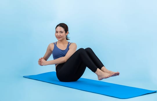 Asian woman in sportswear doing crunch on exercising mat as workout training routine. Attractive girl in pursuit of healthy lifestyle and fit body physique. Studio shot isolated background. Vigorous