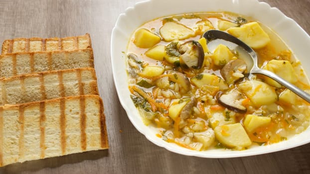 Mushroom soup in a white bowl on a beige background. High quality photo