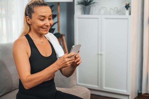 Active and sporty senior take selfie with smartphone after finishing home workout exercise. Healthy and fit body lifestyle for pensioner after retirement workout exercising at home. Clout