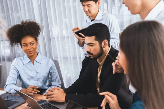 Happy diverse business people work together, discussing in corporate office. Professional and diversity teamwork discuss business plan on desk with laptop. Modern multicultural office worker. Concord