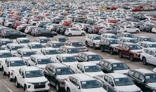 Lamchabang, Thailand - July 02, 2023 Rows of brand new cars in a bustling factory warehouse depict modern car manufacturing and global industryan industry in motion.