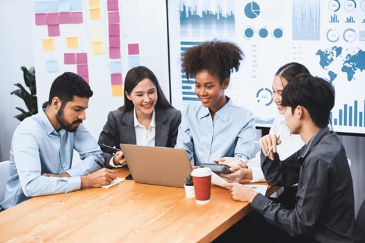 Multiracial analyst team use BI dashboard data to analyze financial report on meeting table. Group of diverse business people utilize data analysis by FIntech for success business marketing. Concord