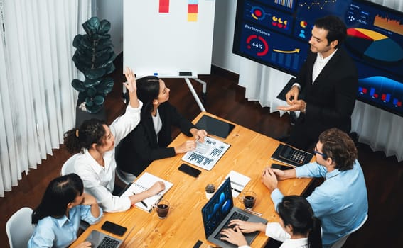 Wide top view of diverse group of business analyst team analyzing financial data report paper on meeting table. Chart and graph dashboard by business intelligence analysis. Meticulous