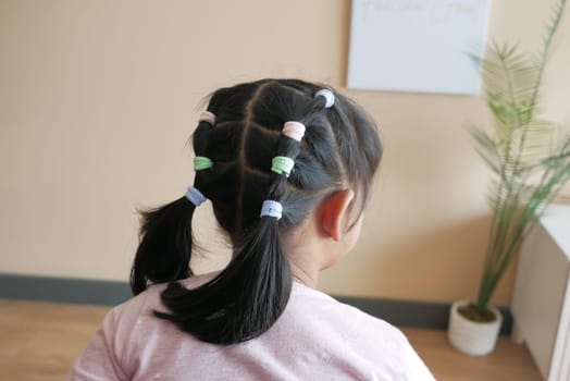 Beautiful ribbon is tied on a child hair .