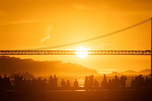 A group of people standing in front of a bridge