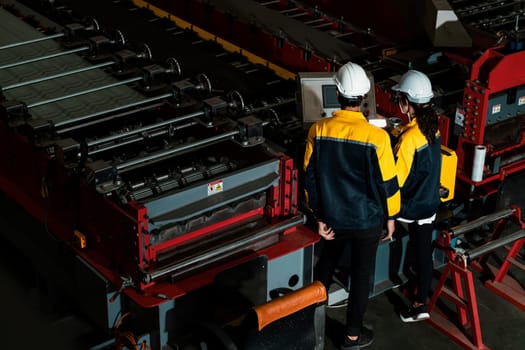 Factory quality control inspector conduct safety inspection on steel machinery and manufacturing process. Engineer or operator make optimization in heavy industry. Top wide view Exemplifying