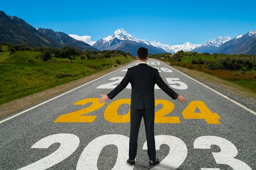 2024 New Year journey and future vision concept . Businessman traveling on highway road leading forward to happy new year celebration in beginning of 2024 for bliss and successful start .