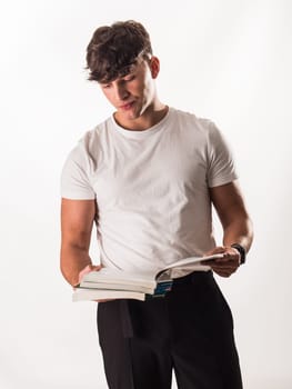 A man in a white shirt is reading a book looking bored. Man in White Shirt Immersed in Thoughtful Reading