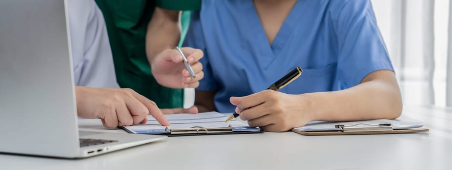 Professional various team of medical working and planning medical treatment at hospital table together. Teamwork lead to successful illness and sickness treatment. Panorama Rigid