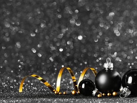 gold and black christmas balls on black bokeh background