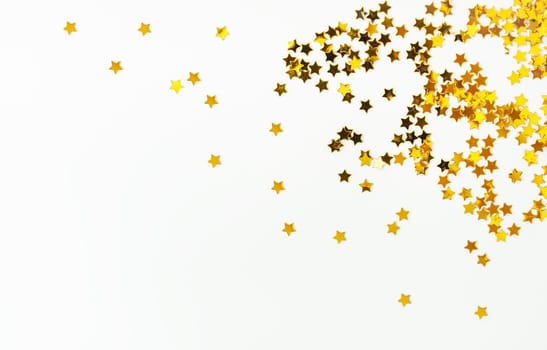 Candies with a golden little star scattered on a white background, concentrated on the right side, there is a place for an inscription