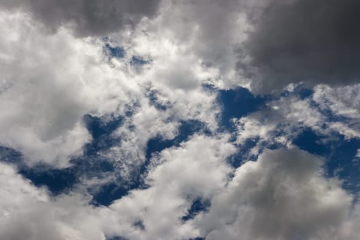overcast sky, full-frame gray clouds with gaps of blue sky.