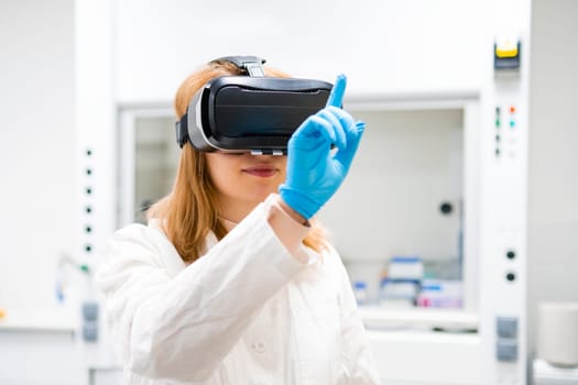 Woman scientist in VR goggles uses augmented reality for making analysis at the laboratory.