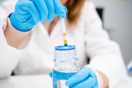 Strips for measurement of acidity for pH test in scientists hand.