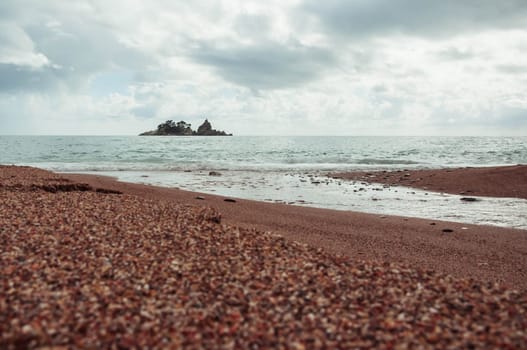 landscape photo of an evening beach overlooking the sea, an island can be seen in the distance, a photo of a sunset on the sea. High quality photo