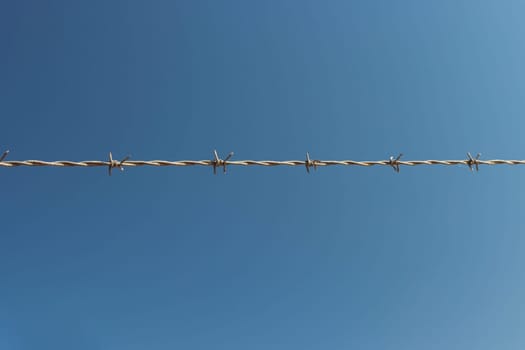 barbed wire against the blue sky, a beautiful landscape there is a place for an inscription. High quality photo