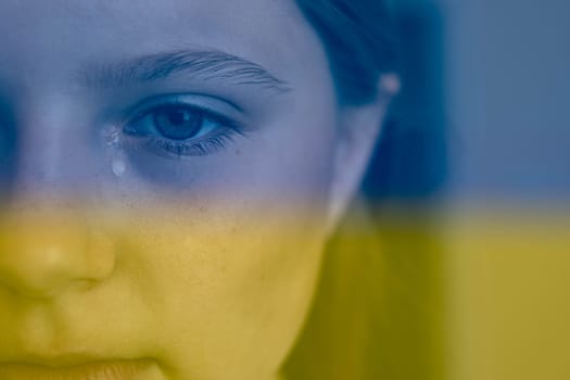 ukrainian baby girl crying on the right side a place for your inscription is.Ukraine flag background blue and yellow color background.Stop the war in ukraine. High quality photo