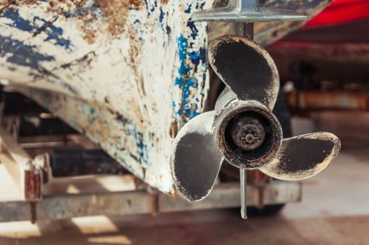 bottom block of an outboard motor with a propeller close-up, rear view of an old boat. High quality photo