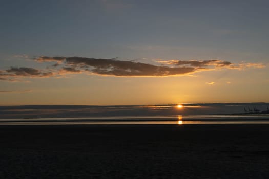 beautiful sunset on the shore of the sea the sky is golden in color due to the sun. High quality photo