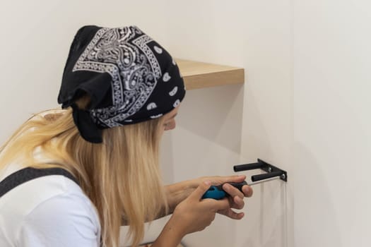 the girl spins the shelf for books on the wall. the girl, blond hair and a black bandana on her head, gender equality. On the right there is a place for an inscription. High quality photo