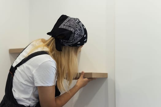 Destruction of gender stereotypes. A woman in a male work suit using various male work tools.. The girl is working on the repair of the apartment. woman in a male profession. High quality photo