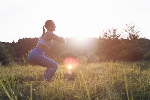 a girl of fair appearance with tied hair, in a fitness suit, is engaged in exercises at dawn in the park,there is a place for an inscription. The concept of a healthy lifestyle. High quality photo