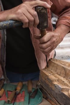 a man makes products from a tree with his own hands and with a tool close-up of a hand a tree. High quality photo