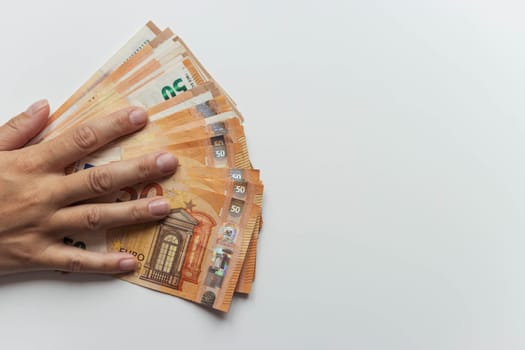 a man's hand close-up on a white background holds a hand spread out euros for 50. with the right there is a place for the inscription beautiful money background. High quality photo