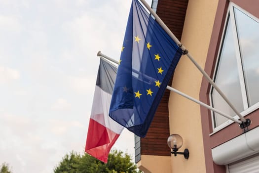 The flag of the European Union and the flag of France flutters in the wind close-up. High quality photo