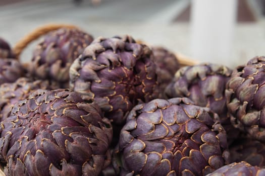 a lot of artichokes close-up. Artichokes are sold on the showcase, healthy food. photo angle from the side. High quality photo