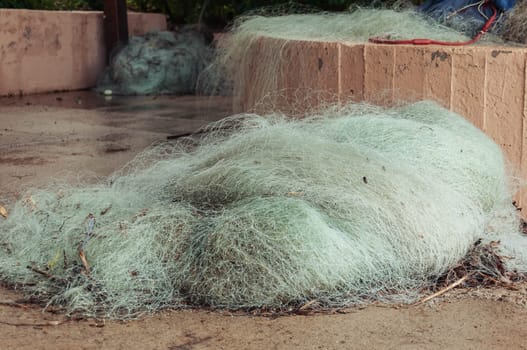 rustic fishing net with buoys and ropes A fishing net is a net used to catch fish. Some fishing nets are also called fish traps. High quality photo