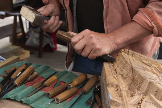 a man makes products from a tree with his own hands and with a tool close-up of a hand a tree. High quality photo