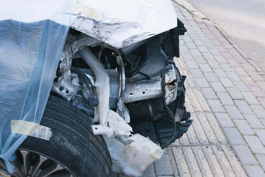 a broken car after an accident, the bumper of the car is completely broken after an accident on the road. High quality photo